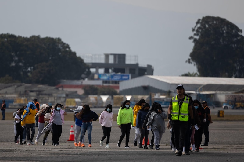 Migrantes centroamericanos caminan por una pista de aterrizaje en el aeropuerto de Tapachula, Chiapas, México.