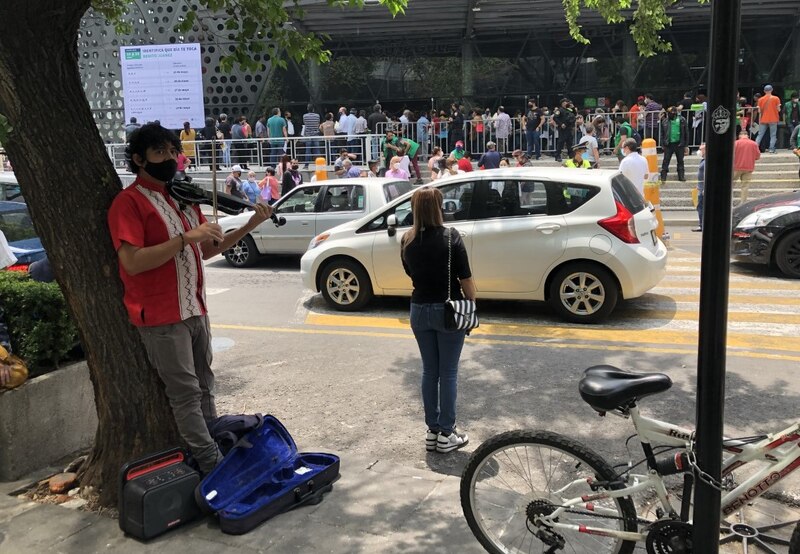 Un violinista callejero toca para una mujer en bicicleta