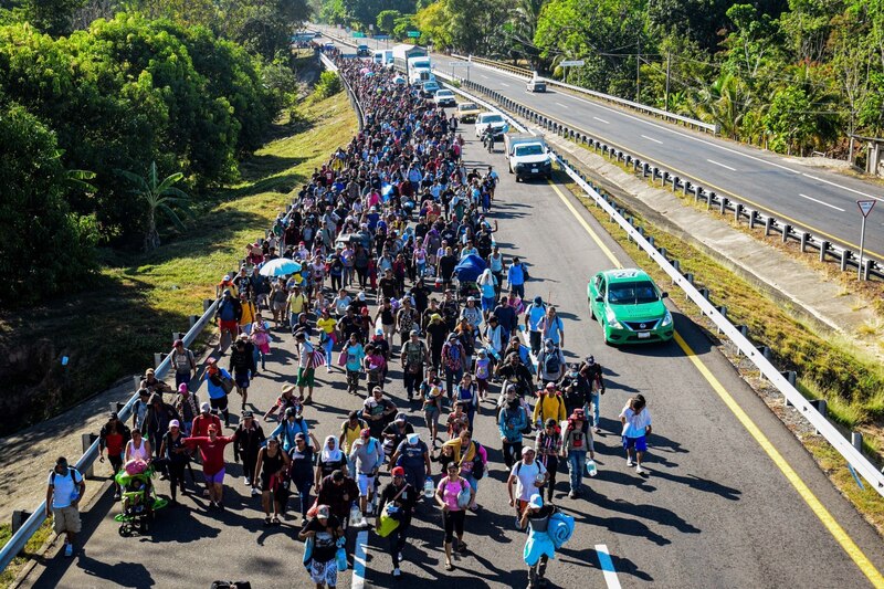 Migrantes caminan en caravana por carretera en México