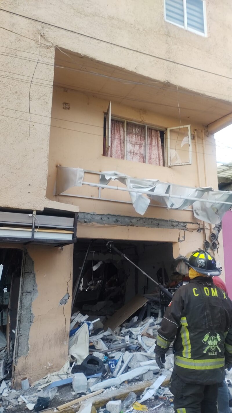 Bombero inspecciona los daños causados por una explosión en un edificio