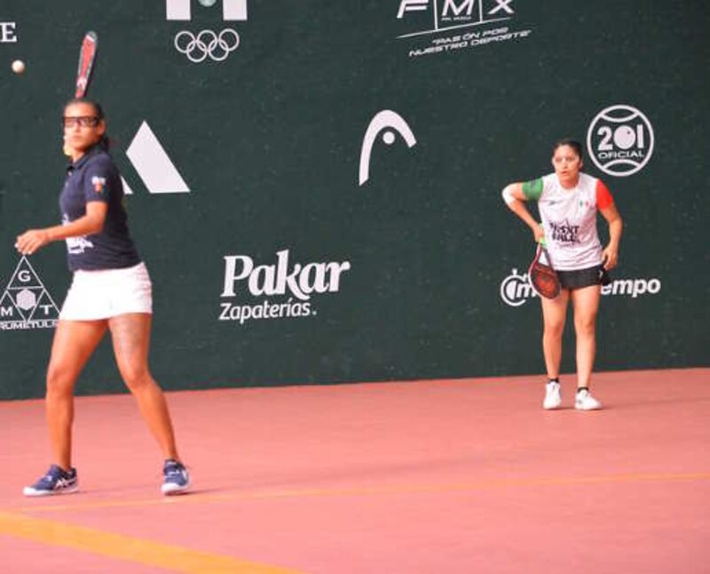 Dos mujeres juegan al frontenis en un partido de competición.