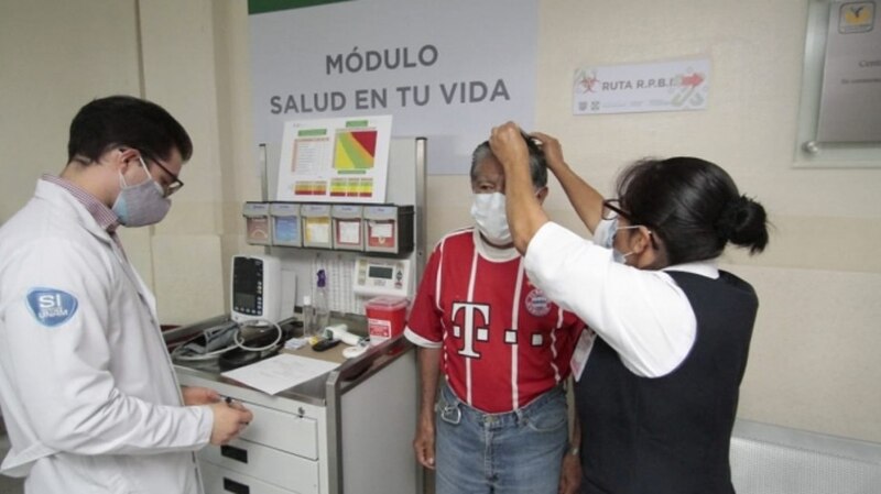 Médico revisa la presión arterial a un paciente.