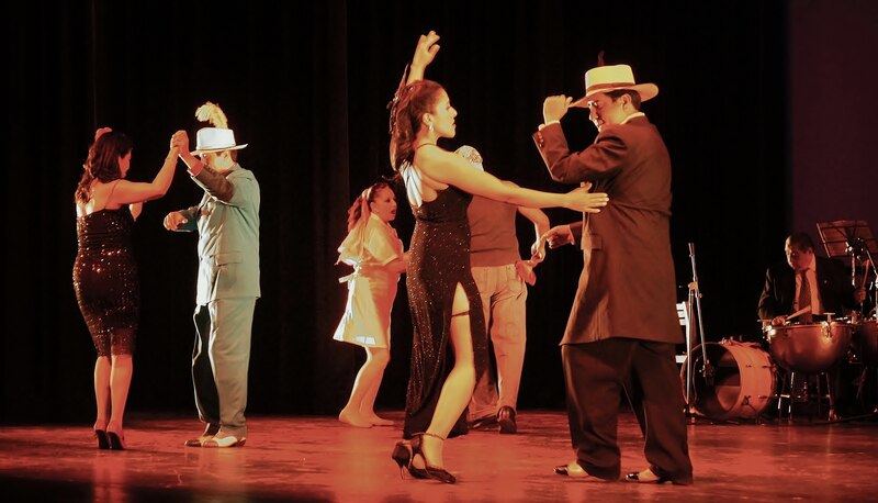 Parejas bailando salsa en un escenario