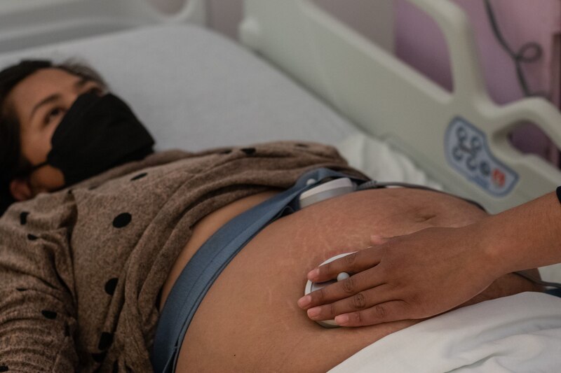 Mujer embarazada en el hospital siendo examinada por un médico.