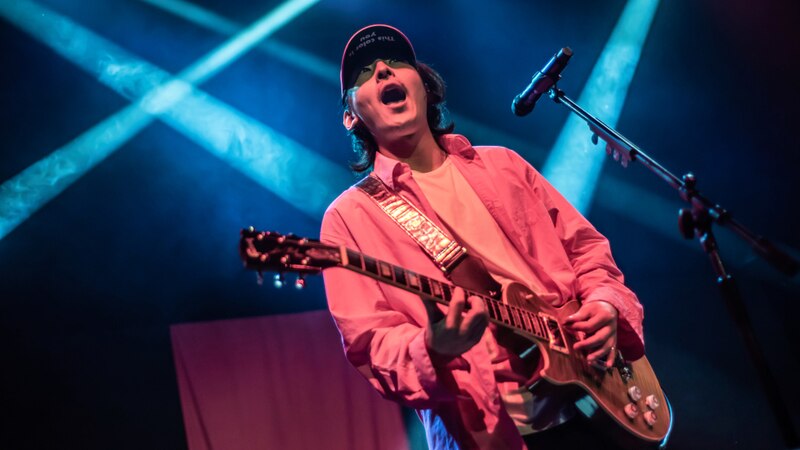 Cantante tocando la guitarra en un concierto