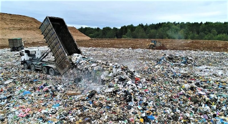 Un camión vierte basura en un vertedero