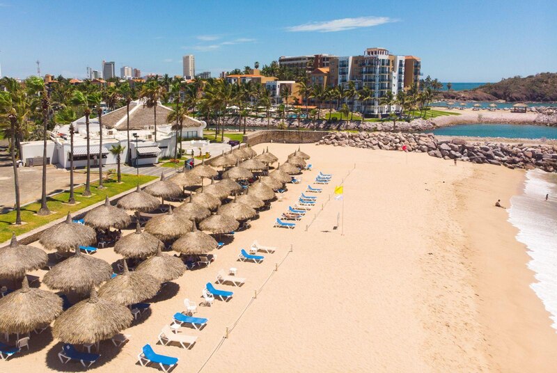 Playa con sombrillas y sillas en un día soleado