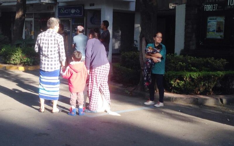 Un grupo de personas esperando en la fila para entrar a un banco