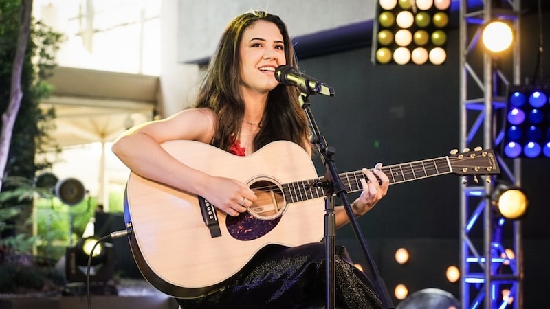 Cantante tocando la guitarra en un concierto