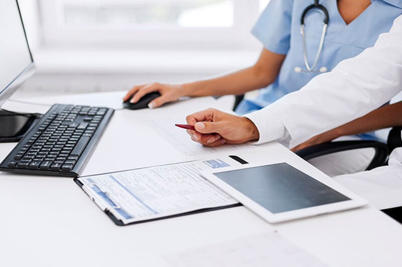 Médico y enfermera revisando historias clínicas