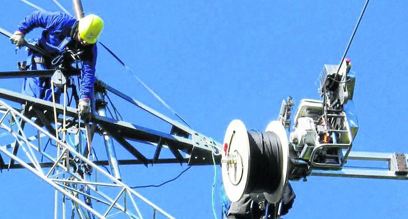 Un trabajador de la compañía eléctrica repara una línea eléctrica.