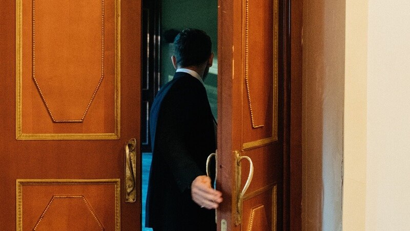 Un hombre abre una puerta