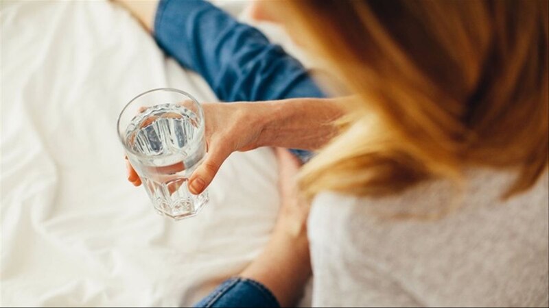 Mujer sosteniendo un vaso de agua