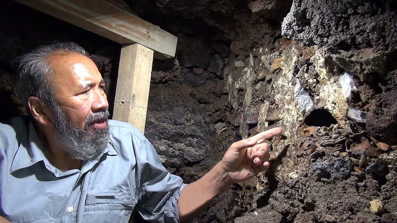 Un arqueólogo examina un antiguo muro de piedra