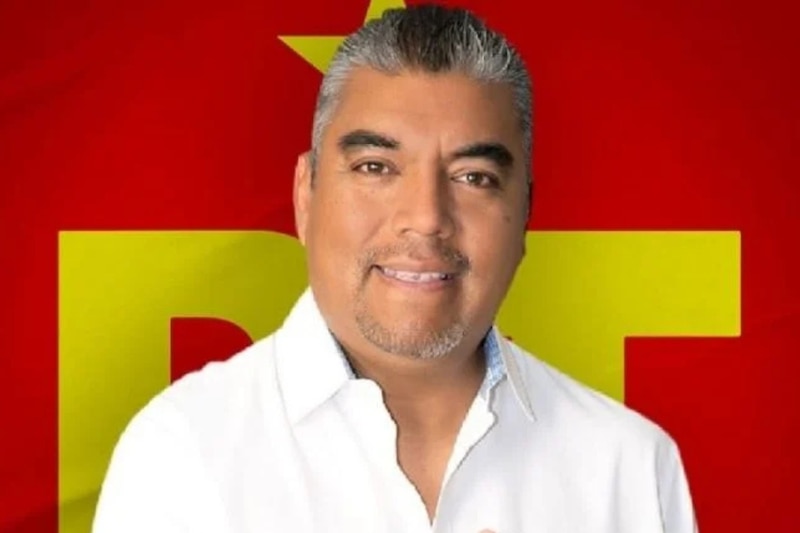El político Isaías Rojas Ramírez en un fondo con la bandera del PT