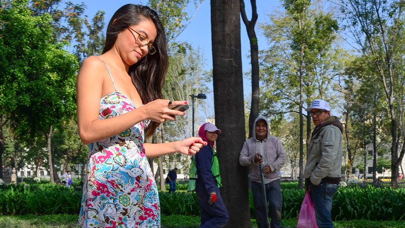 Mujer mirando su teléfono celular en un parque