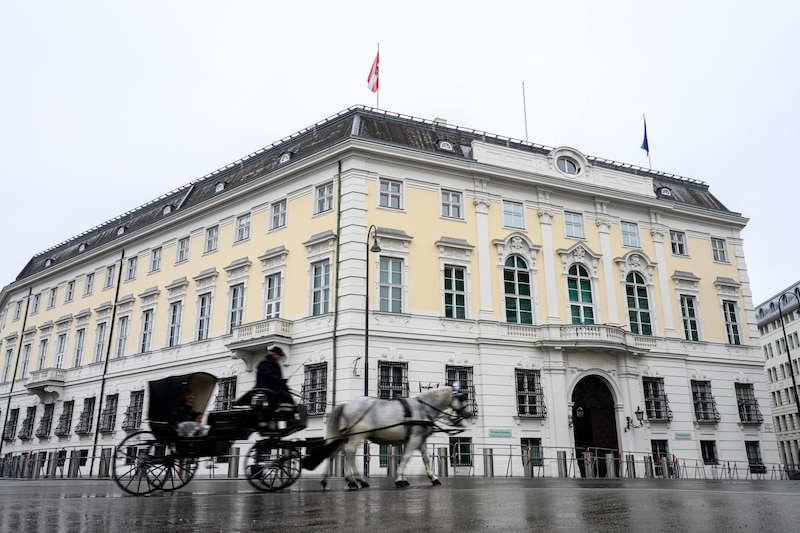 Un carro tirado por caballos pasa por delante de la Cancillería Federal de Austria