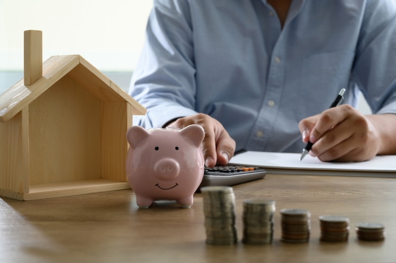 Hombre contando dinero para comprar una casa