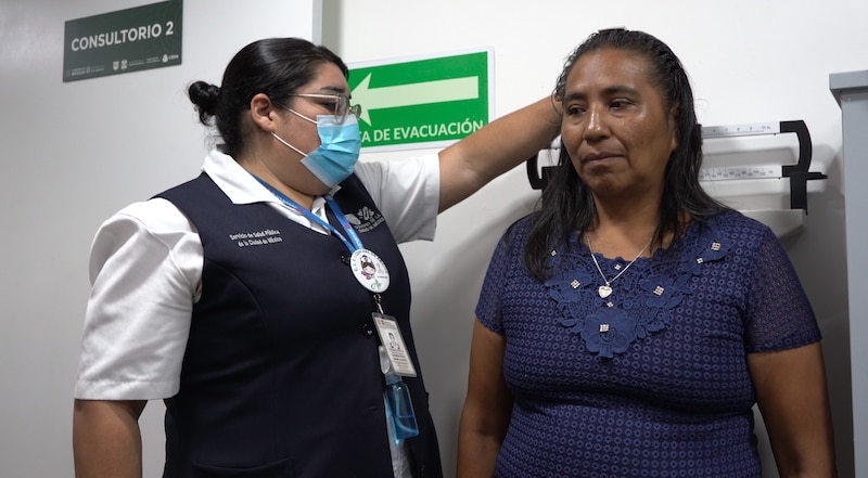 Mujer indígena se mide la estatura en una clínica de salud pública en México