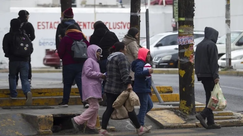 Personas caminando por la calle en un día lluvioso