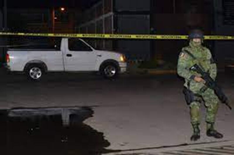 Soldado mexicano resguarda una camioneta blanca en la noche