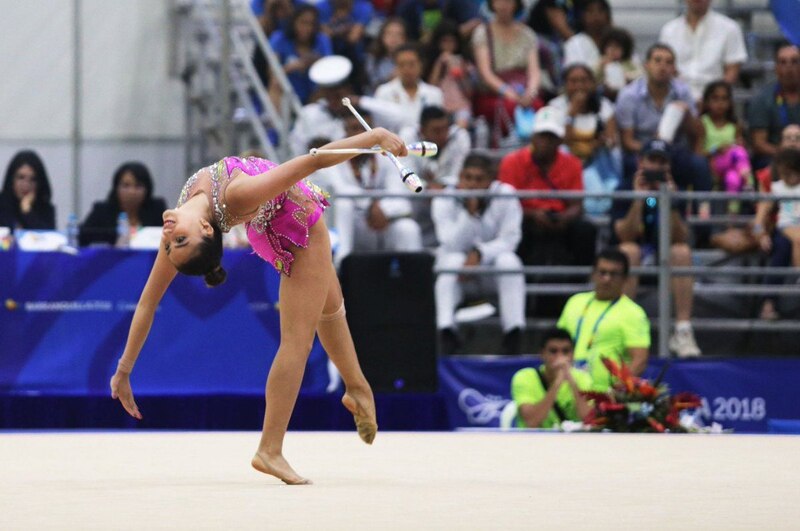 Gimnasta rítmica realiza una pirueta con mazas