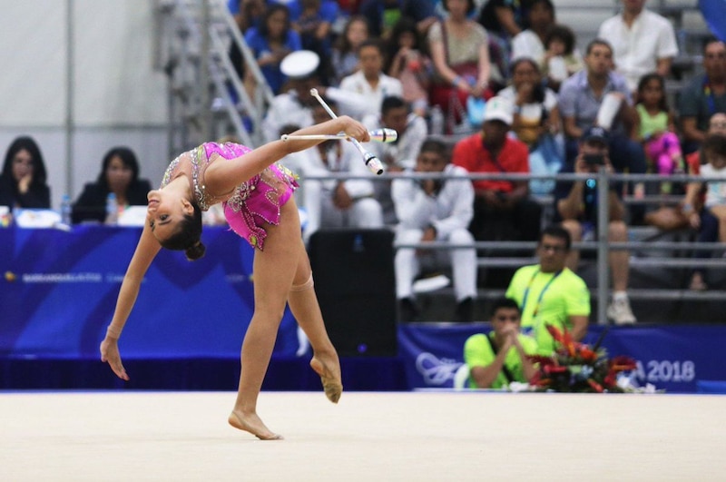 Gimnasta rítmica realiza una pirueta con mazas