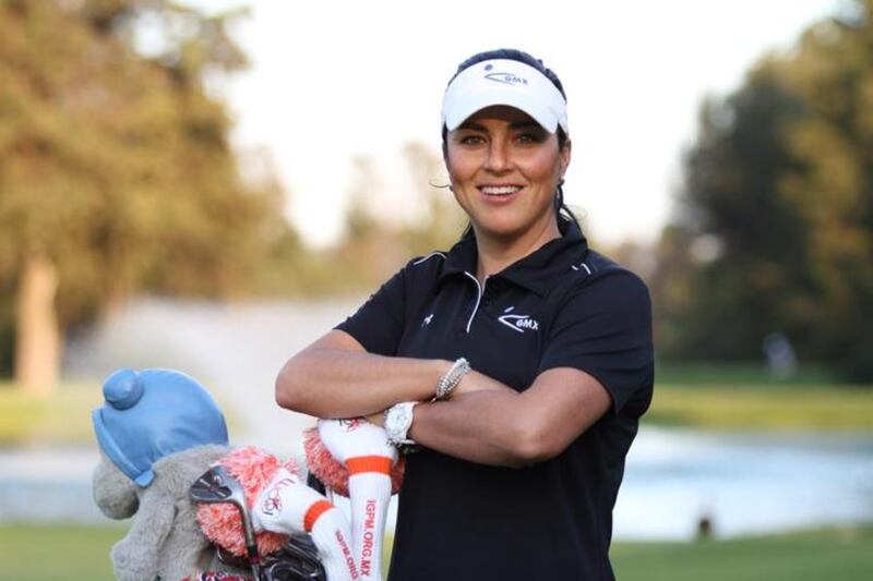 La golfista Lorena Ochoa, sonriente y con los brazos cruzados, se apoya en su bolsa de palos.