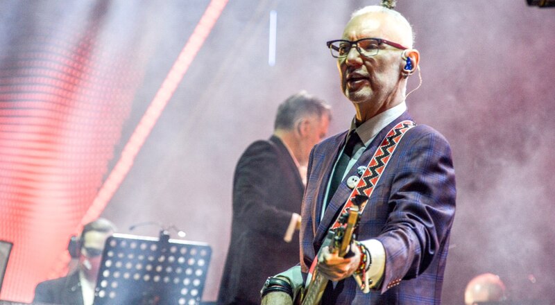 El músico Sting tocando el bajo en un concierto