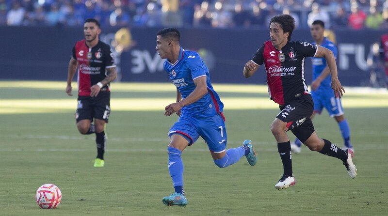 Jugadores de fútbol corriendo tras el balón