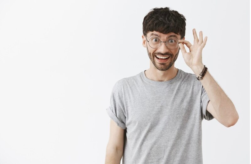 Hombre joven con gafas haciendo el signo de OK