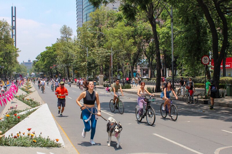 Mujer corriendo con su perro en una calle de la ciudad