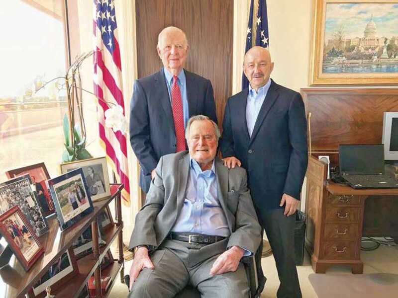 El expresidente Jimmy Carter con dos hombres sonrientes.
