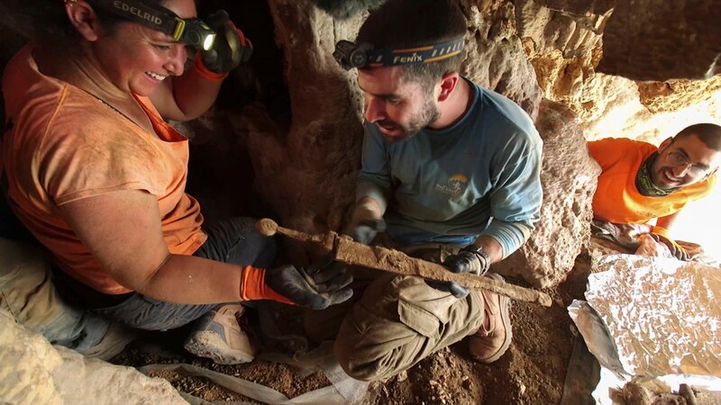 Un equipo de arqueólogos desenterrando un antiguo tesoro en una cueva