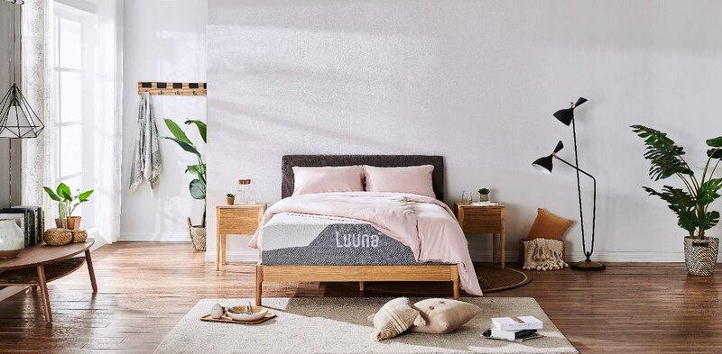 Dormitorio con cama, mesitas de noche y plantas