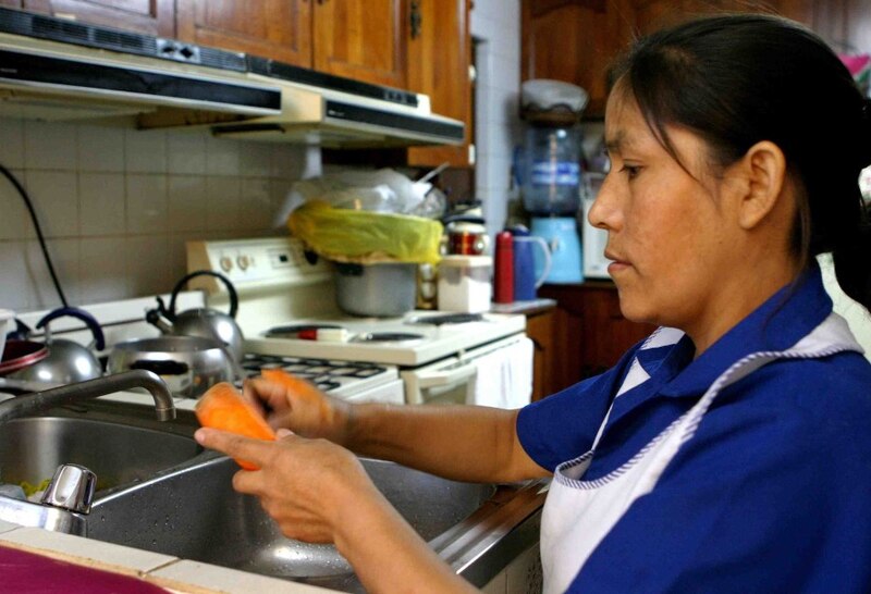 Mujer lavando platos en la cocina