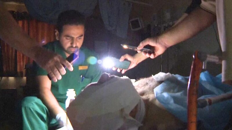 Médico usando una linterna para examinar a un paciente en una ambulancia.