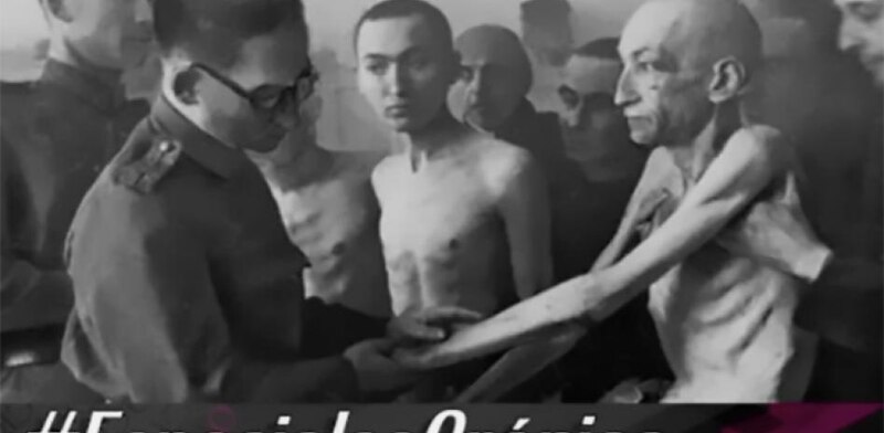 La imagen muestra a un grupo de prisioneros en un campo de concentración nazi. Están desnudos y demacrados, y se les ve claramente las costillas. Un oficial nazi les está dando la bienvenida. La imagen es un testimonio del horror del Holocausto.