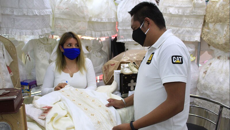 Hombre y mujer mirando ropa de bebé