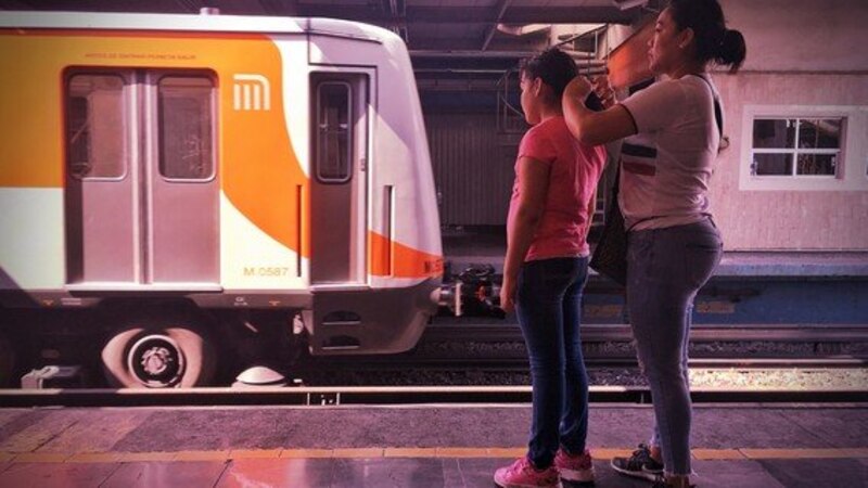 Madre e hijo esperan el metro