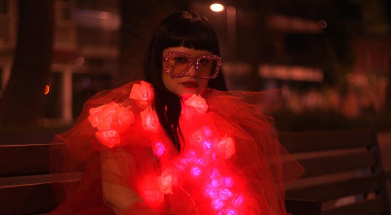 Mujer con vestido rojo y gafas de sol rosas