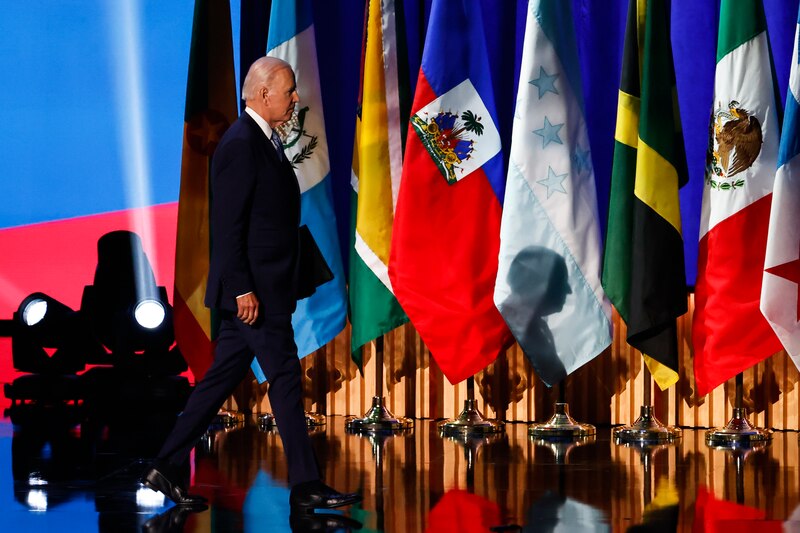 El presidente Biden camina frente a banderas de países latinoamericanos