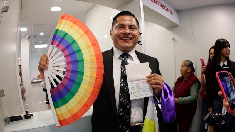 Un hombre transgénero muestra su pasaporte con su nueva identidad de género.