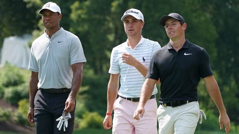 Tiger Woods, Justin Thomas y Rory McIlroy caminan juntos en el campo de golf