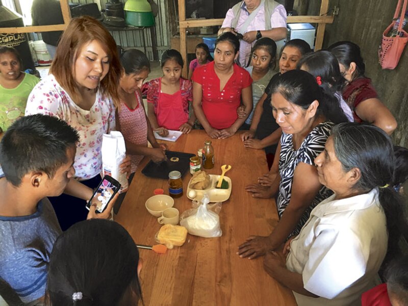 Mujeres indígenas aprenden a hacer pan en un taller comunitario