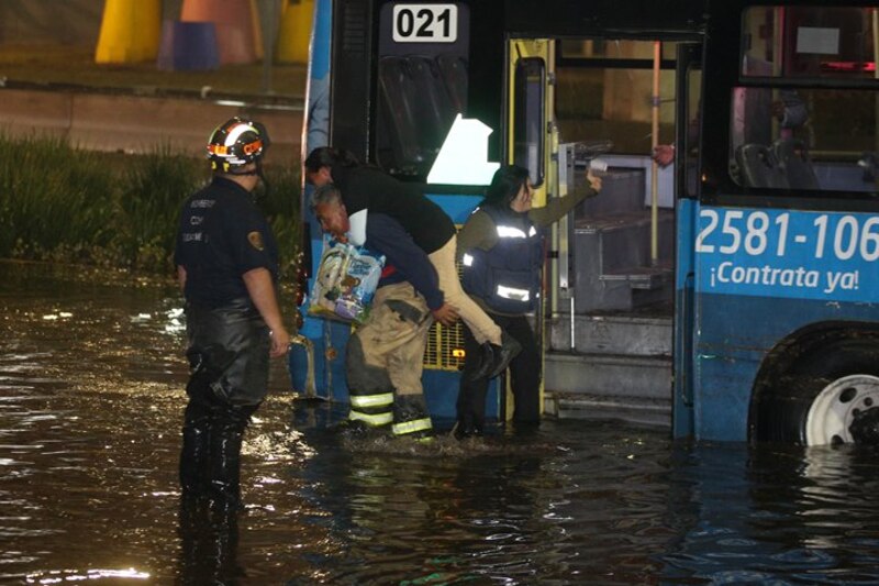 Bomberos rescatan a personas de un autobús inundado