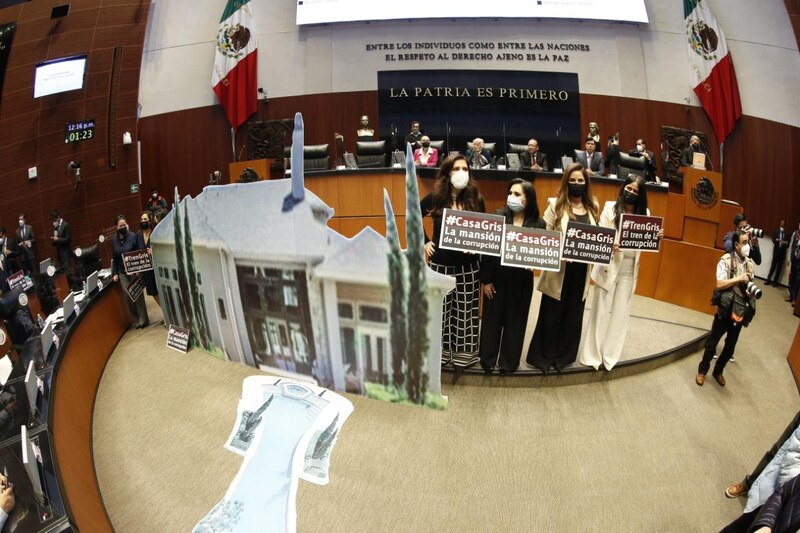 Diputadas exhiben carteles con la imagen de la casa gris durante la comparecencia del titular de la UIF, Santiago Nieto.