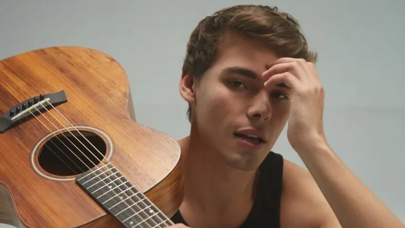 Joven cantautor con guitarra acústica