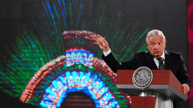 El presidente Andrés Manuel López Obrador da un discurso frente a un mural.