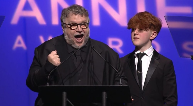 El director de cine Steven Spielberg celebra su premio Óscar junto a un joven actor.